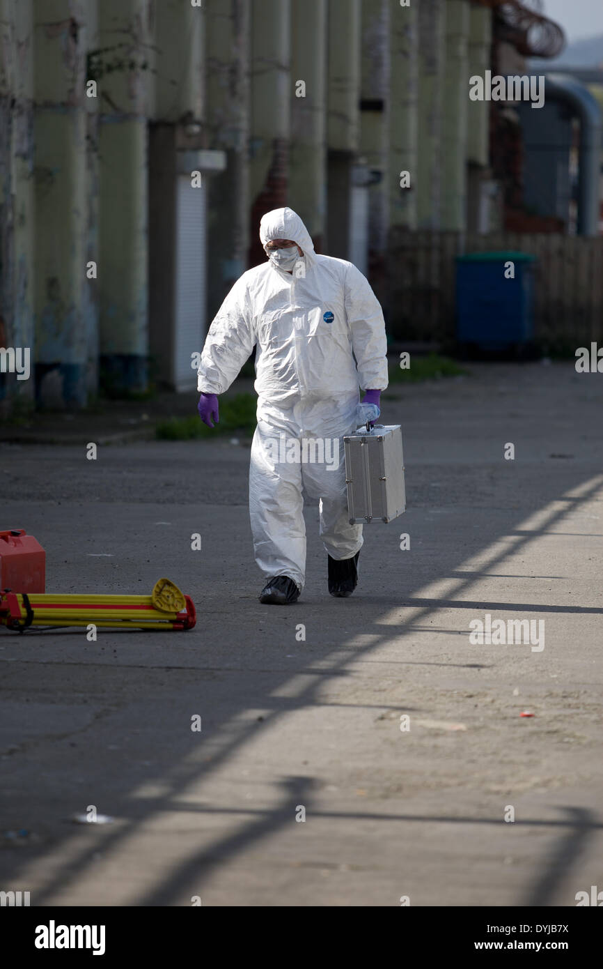 Springfield Road, Belfast,UK 19 aprile 2014 Forensic officer presso la scena del crimine di assassinato il repubblicano Tommy Crossan . Foto Stock