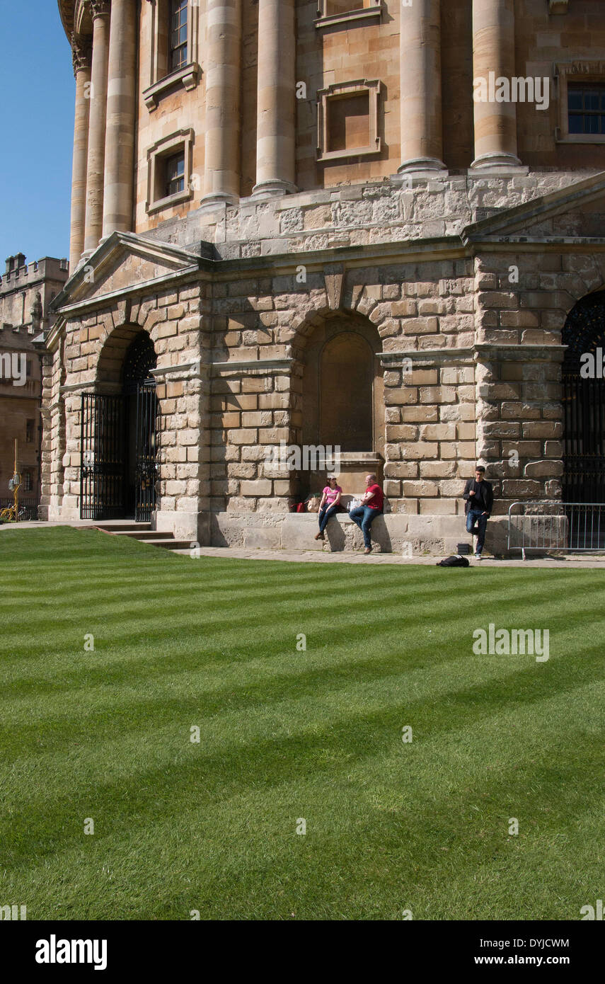 Gli studenti godendo il sole oggi al di fuori della Oxford Bodleian Library Foto Stock