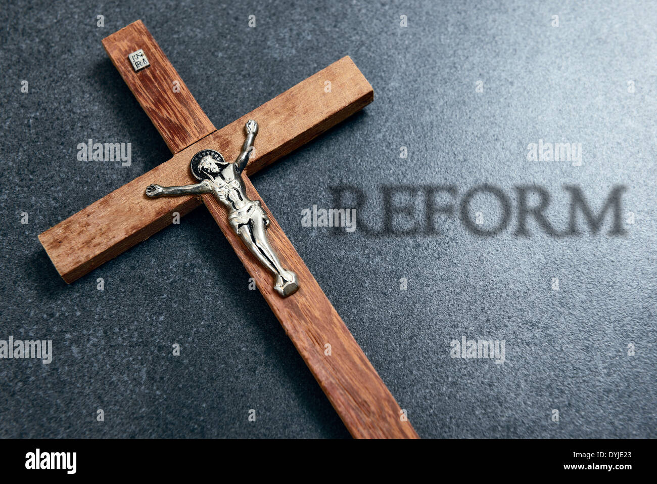 Holzkreuz mit Jesusfigur und Reform-Schriftzug Foto Stock