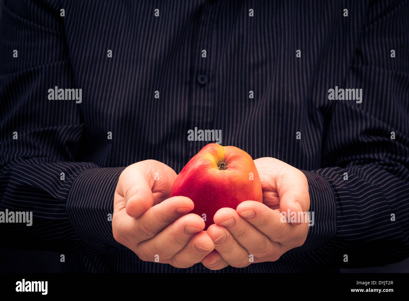 Red apple nelle mani di un uomo Foto Stock