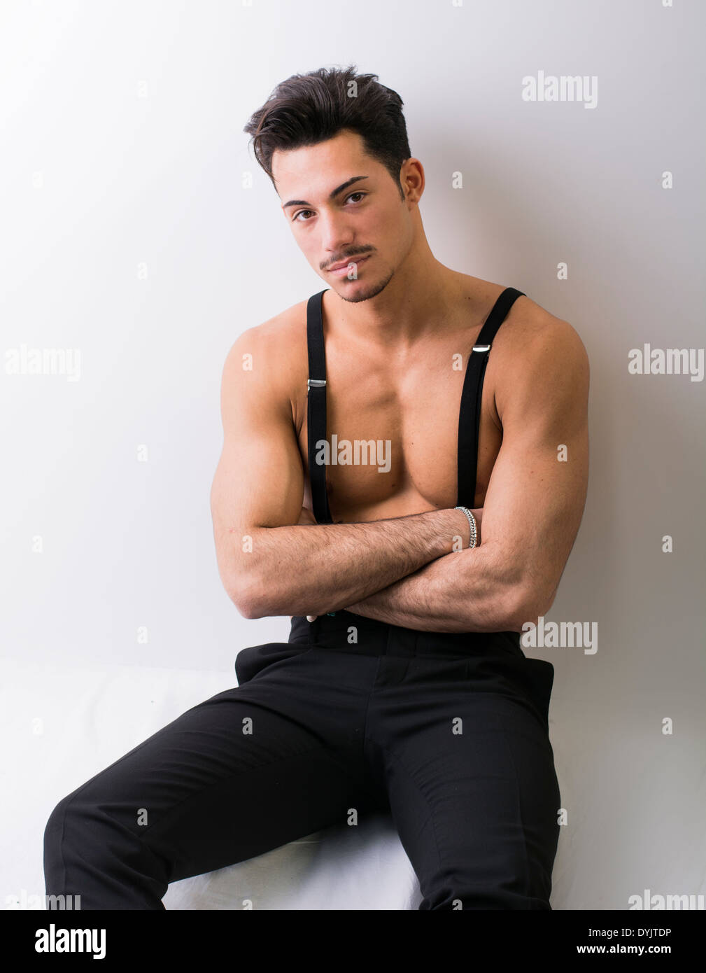Shirtless athletic giovane con bretelle e pantaloni neri, con le braccia  incrociate Foto stock - Alamy