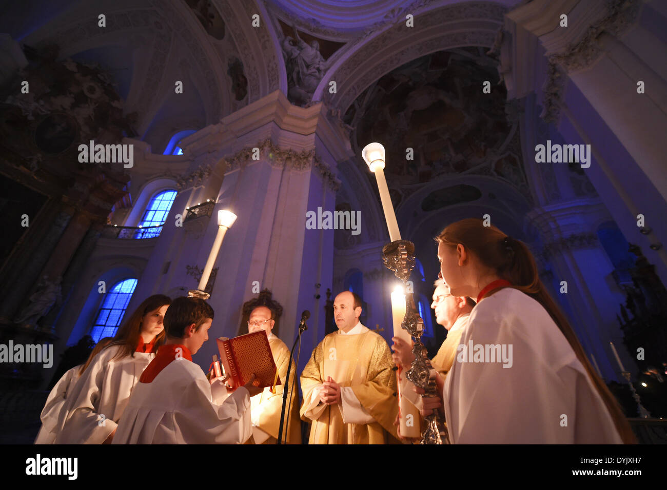 Weingarten, Germania. Xix Apr, 2014. Dean Ekkehard Schmid (C) legge dalla bibbia accanto a un ardente cero pasquale presso la basilica di Weingarten, Germania, 19 aprile 2014. Circa 500 persone hanno partecipato alla risurrezione la Santa Messa presso la basilica. Foto: FELIX KAESTLE/dpa/Alamy Live News Foto Stock