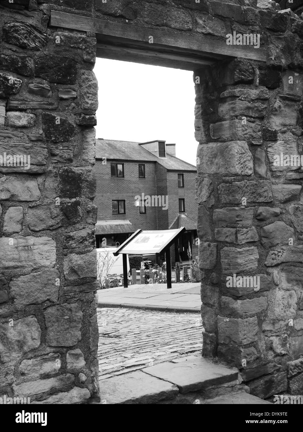 Immagine monocromatica - strada urbana scena che mostra l'apertura / porta nella parete della città, città Trail, Newcastle upon Tyne, England, Regno Unito Foto Stock