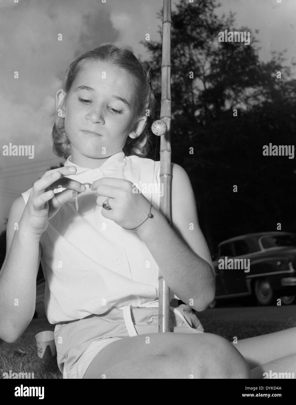 Una ragazza viene vista mentre allatta un gancio durante la Tallahassee Fishathon, un evento di pesca che si tiene al lago Ella a Tallahassee, in Florida. L'evento promuove attività di pesca adatte alle famiglie e introduce i bambini allo sport della pesca. Foto Stock