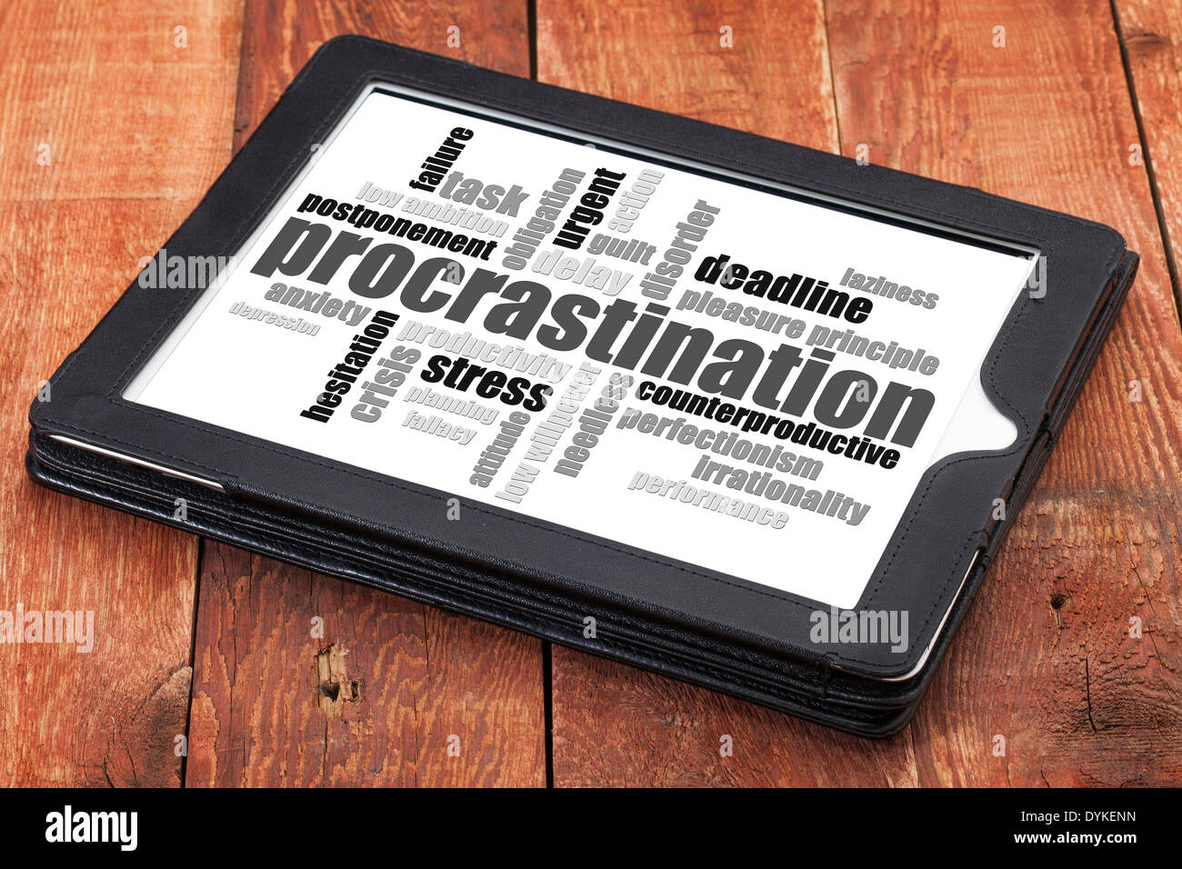 La procrastinazione word cloud su una tavoletta digitale contro il granaio rosso il legno Foto Stock