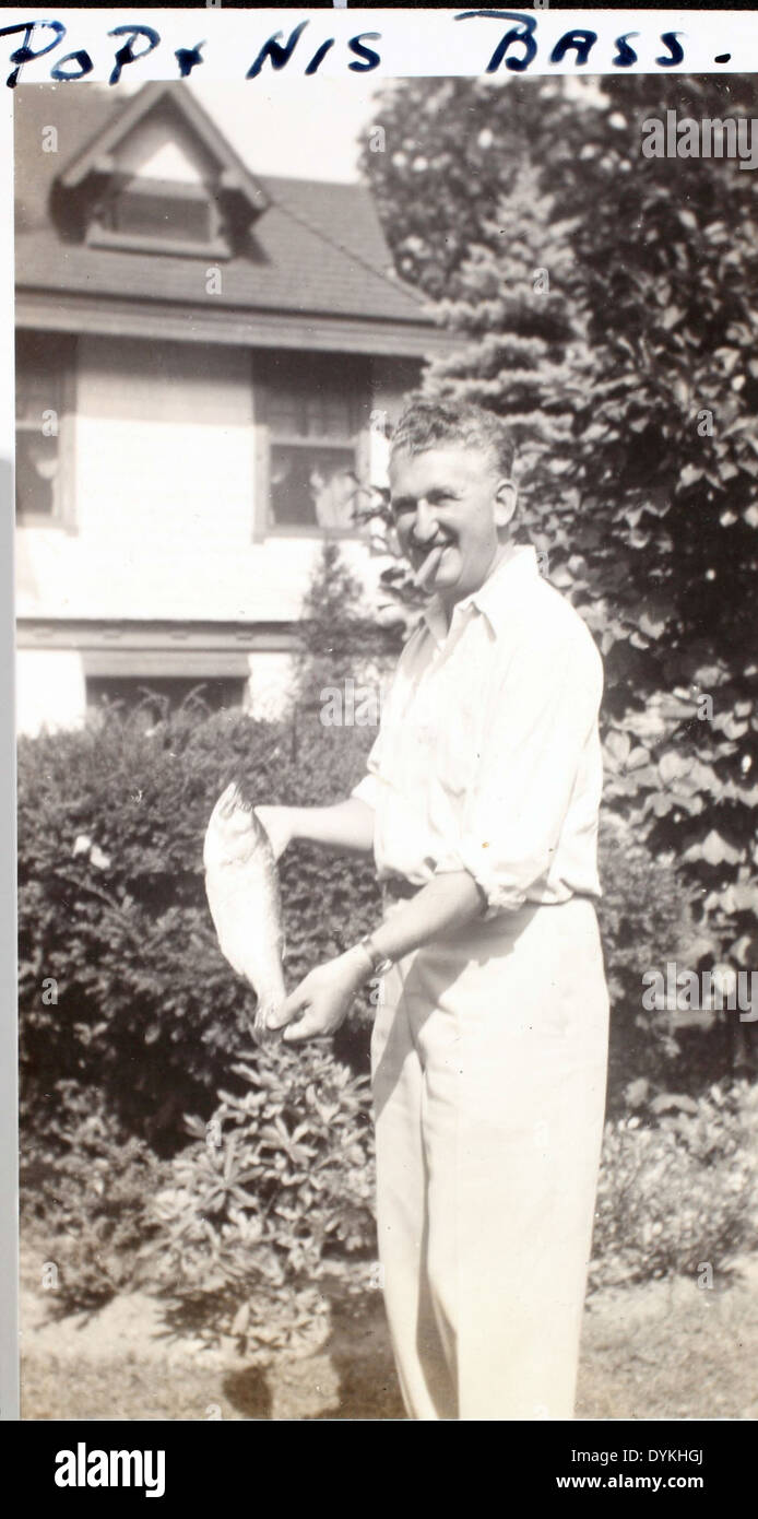 Questa immagine cattura un momento di svago mentre un padre posa orgogliosamente con un pesce di spigola che ha catturato. La fotografia evidenzia un legame personale con la natura e la pesca, riflettendo un'esperienza memorabile al di fuori dell'aviazione. Foto Stock