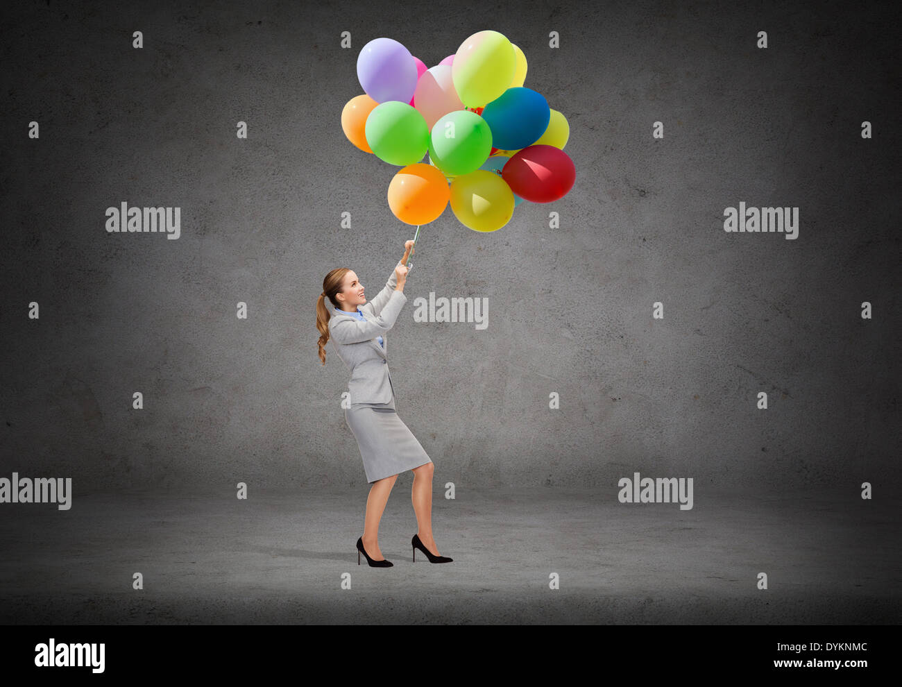 Imprenditrice tirando verso il basso mazzetto di palloncini Foto Stock