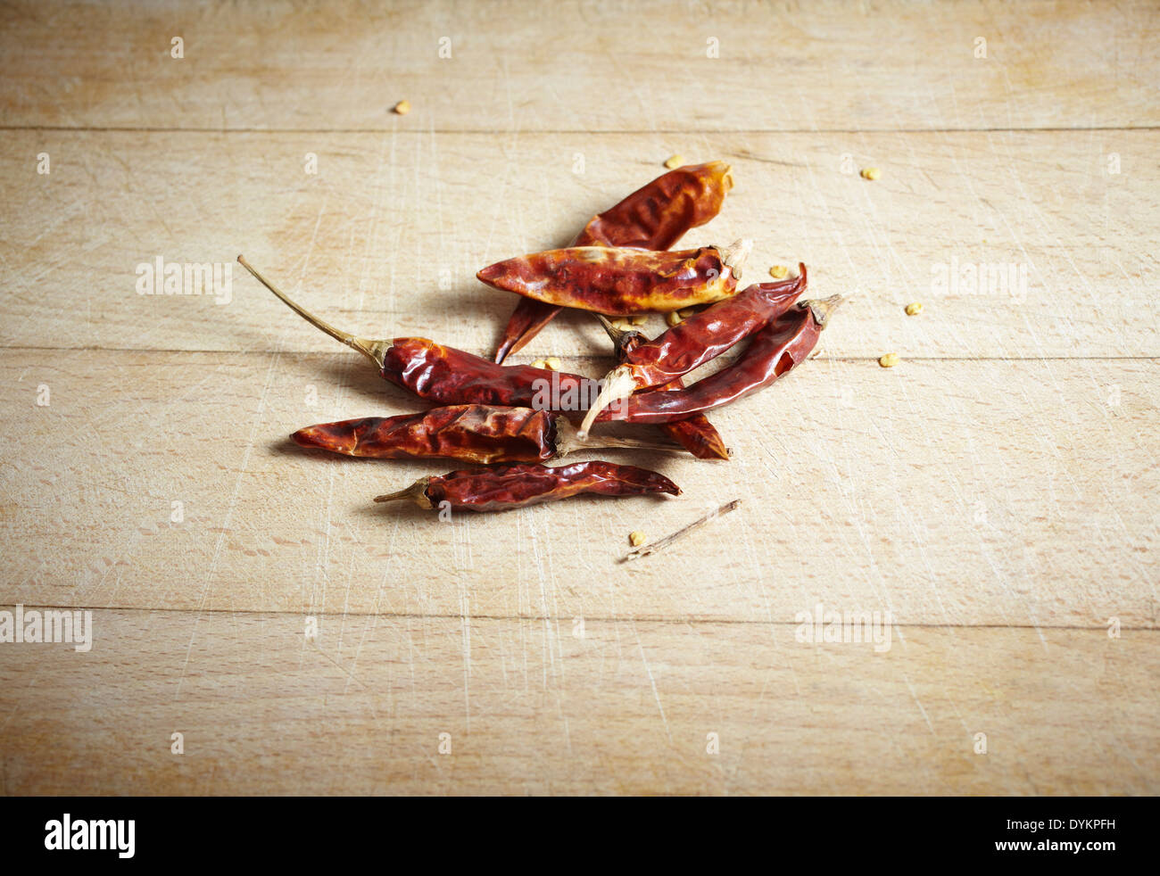 Peperoncini essiccati su un tagliere di legno Foto Stock