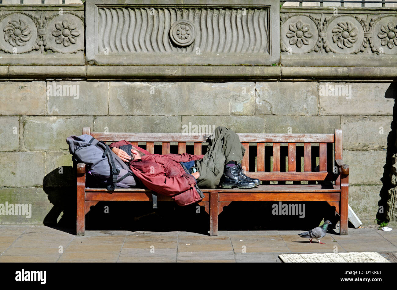 Un vagabondo addormentato su una panchina nel centro di Edimburgo. Foto Stock
