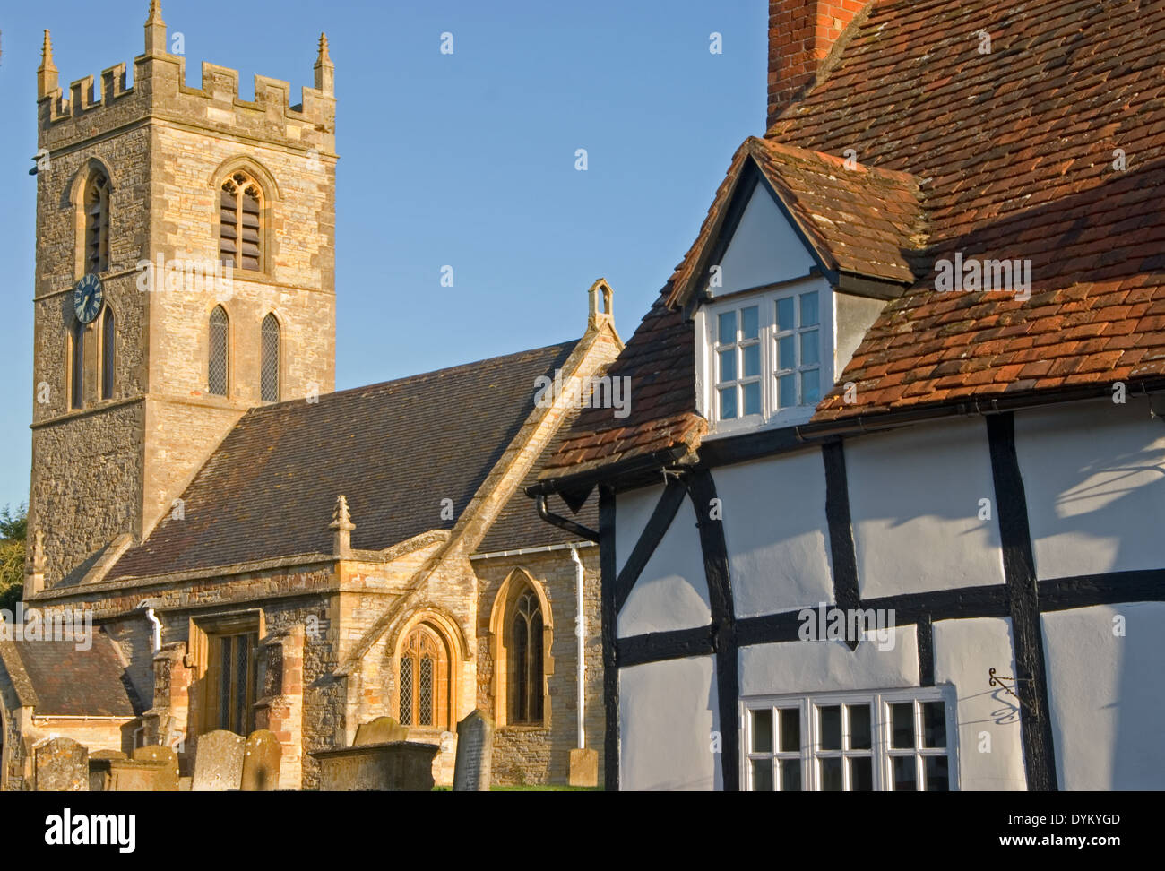 La chiesa del villaggio medievale e metà in legno con travi di legno bianco e nero cottages nel Warwickshire villaggio di Welford on Avon. Foto Stock