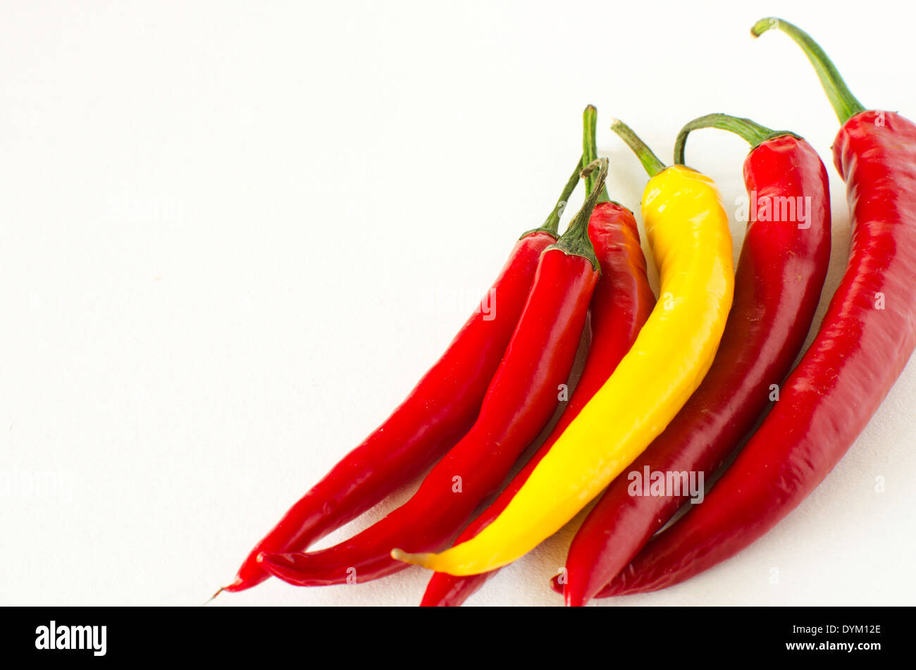 Il giallo e il rosso peperoncino su sfondo bianco Foto Stock