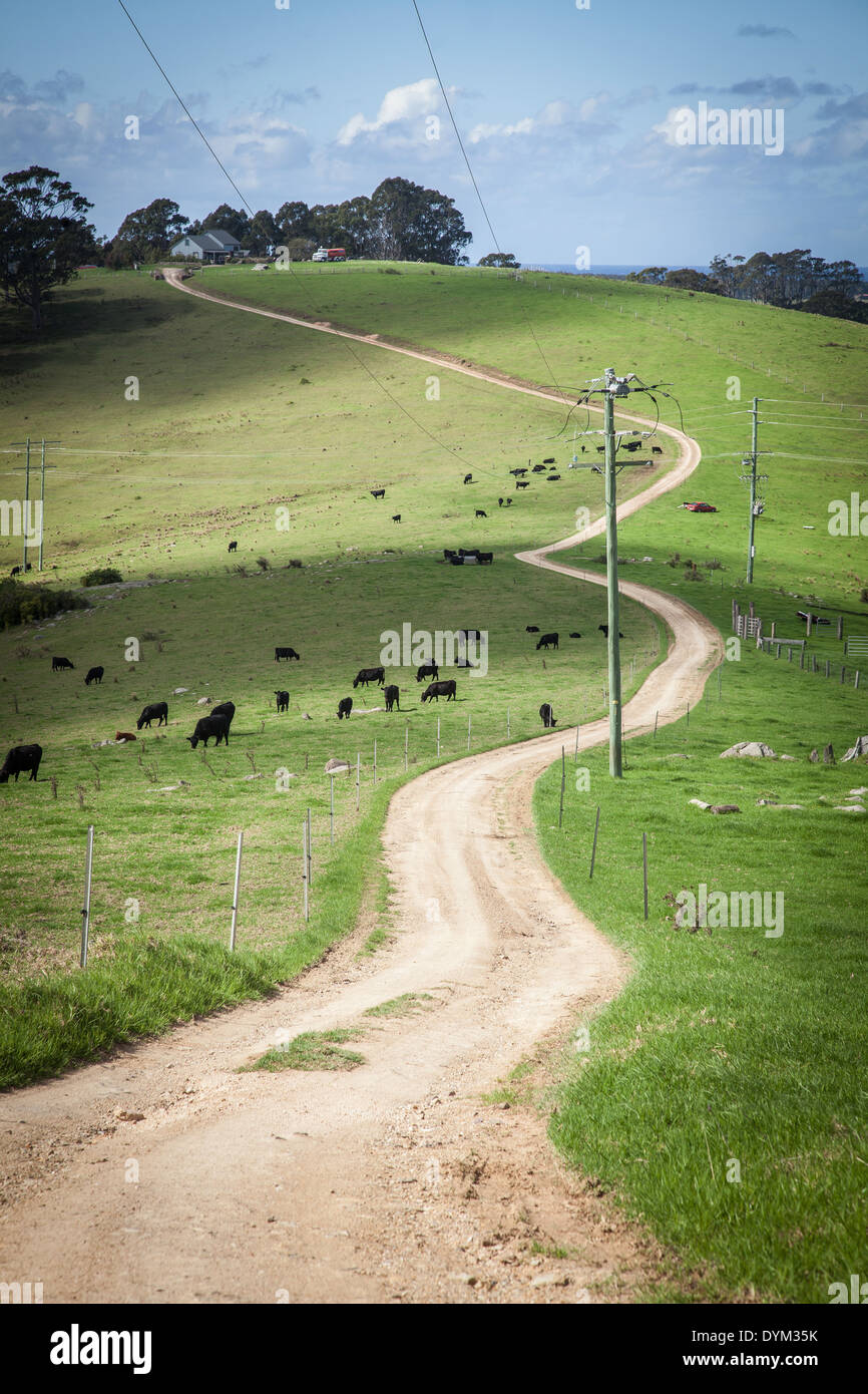 Un tempo paese di avvolgimento su strada sterrata che va fino alla cima di una collina Foto Stock