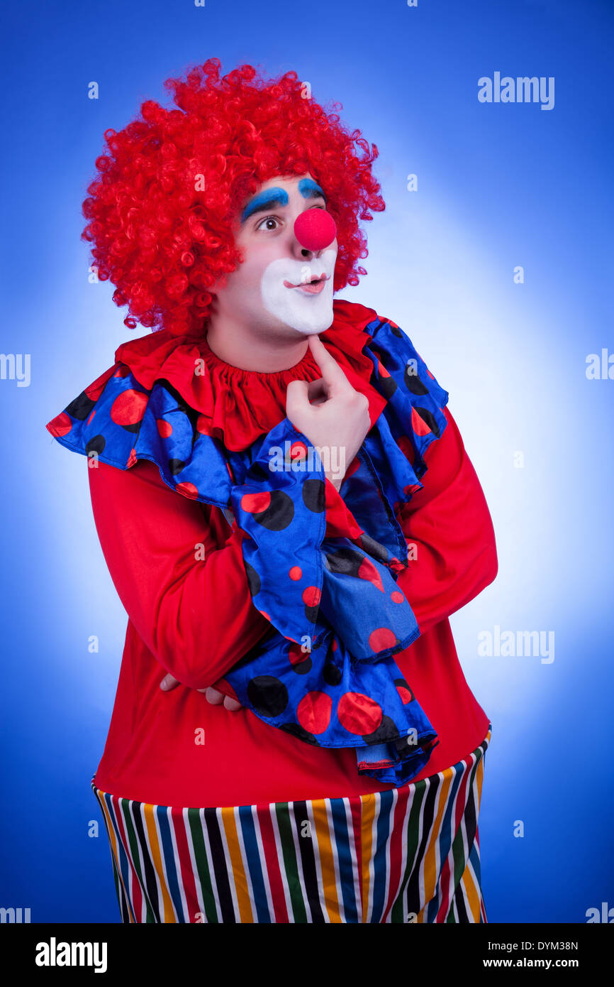 Clown di uomini in abito di circo sfondo blu. Riprese in studio Foto Stock