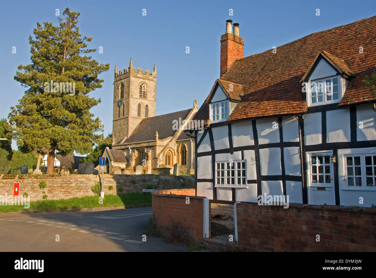La chiesa del villaggio medievale e il graticcio in bianco e nero cottages nel Warwickshire villaggio di Welford on Avon. Foto Stock