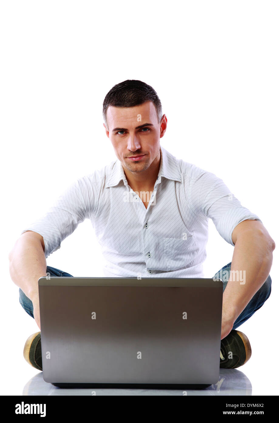 Fiducioso uomo utilizzando laptop sul pavimento su sfondo bianco Foto Stock
