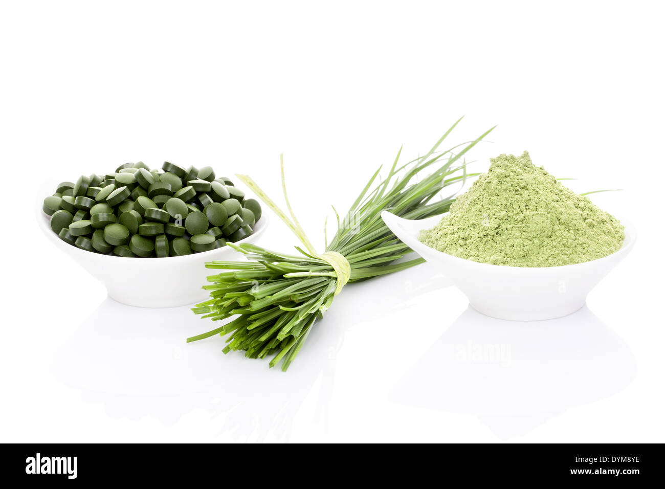 Wheatgrass in polvere, erba di frumento lame, spirulina e chlorella pillole isolati su sfondo bianco. Uno stile di vita sano. Foto Stock