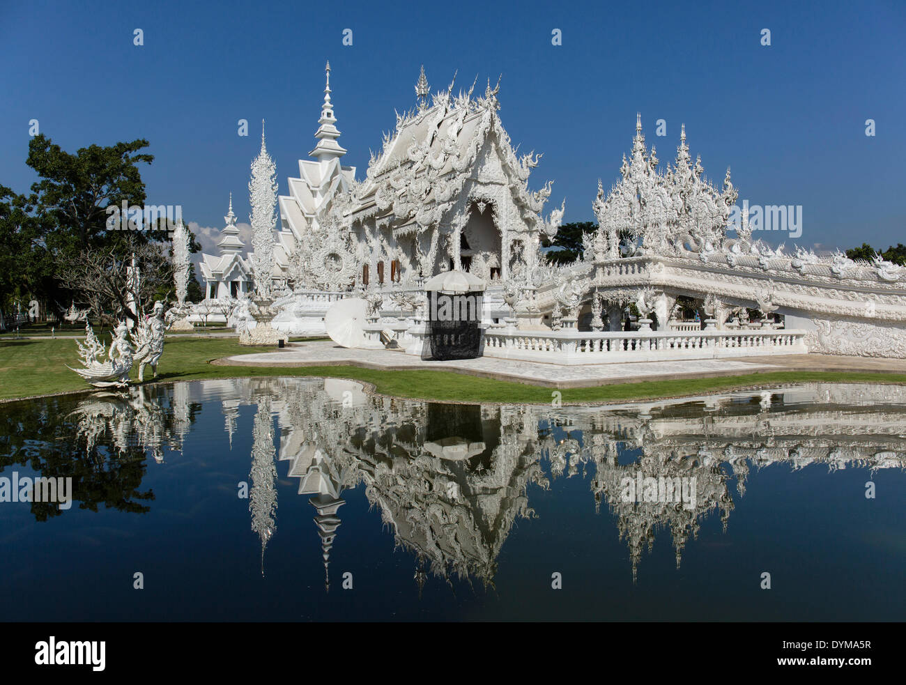 Wat Rong Khun, bianco tempio, dall'architetto Chalermchai Kositpipat, ubosot riflessa nell'acqua, Chiang Rai, provincia di Chiang Rai Foto Stock