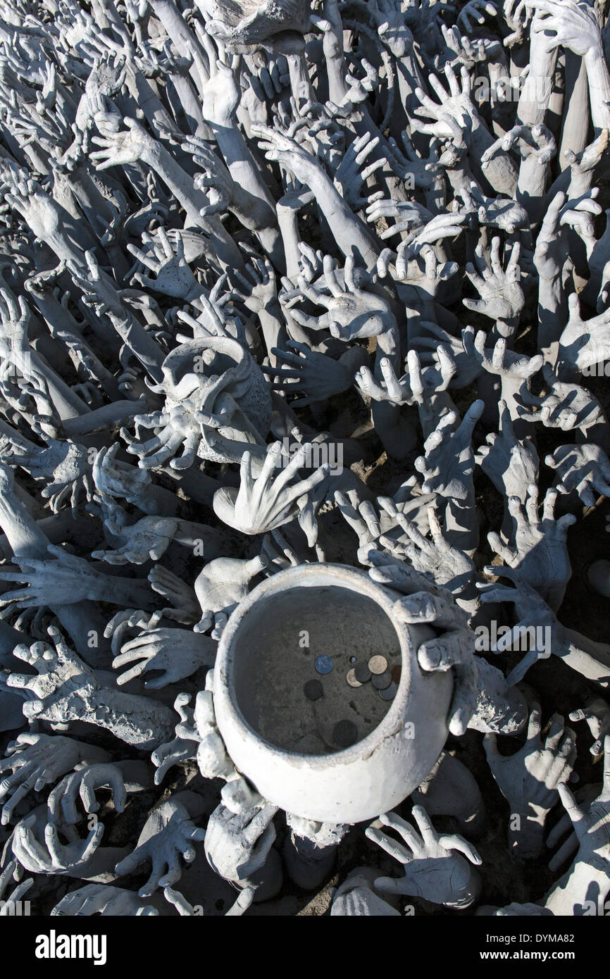 Rappresentazione dell'inferno, mani la supplica di aiuto e una ciotola, al Wat Rong Khun, bridge all'ingresso del tempio Bianco, da Foto Stock