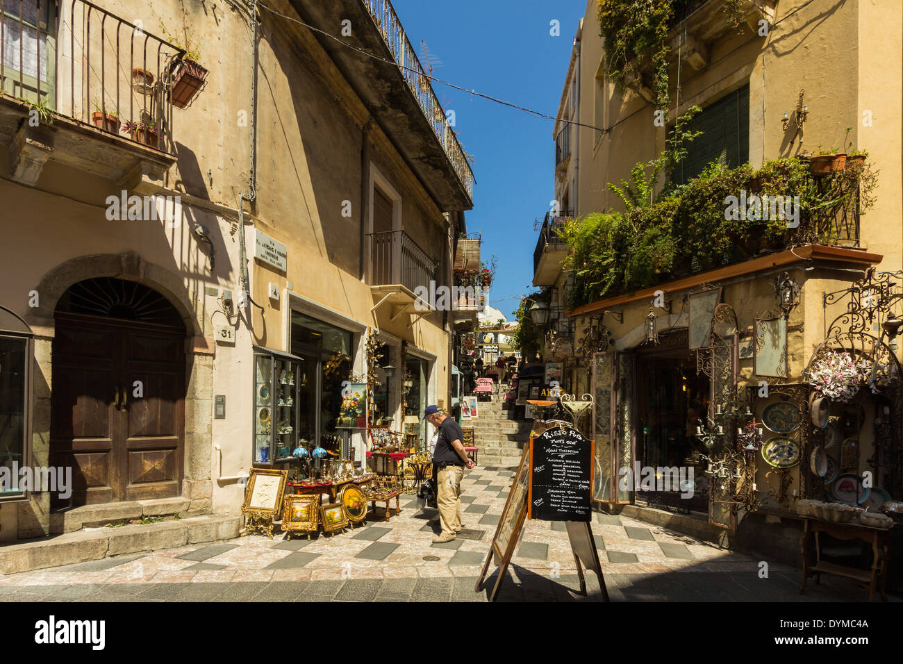 Negozi & pub sulla strada laterale off turistica Corso Umberto in questo popolare ne città turistica; Taormina in provincia di Catania, Sicilia, Italia Foto Stock