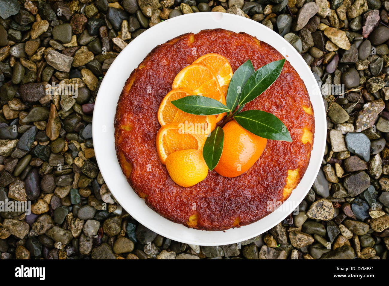 Un aromatizzato al limone polenta torta decorata con mandarini arance Foto Stock