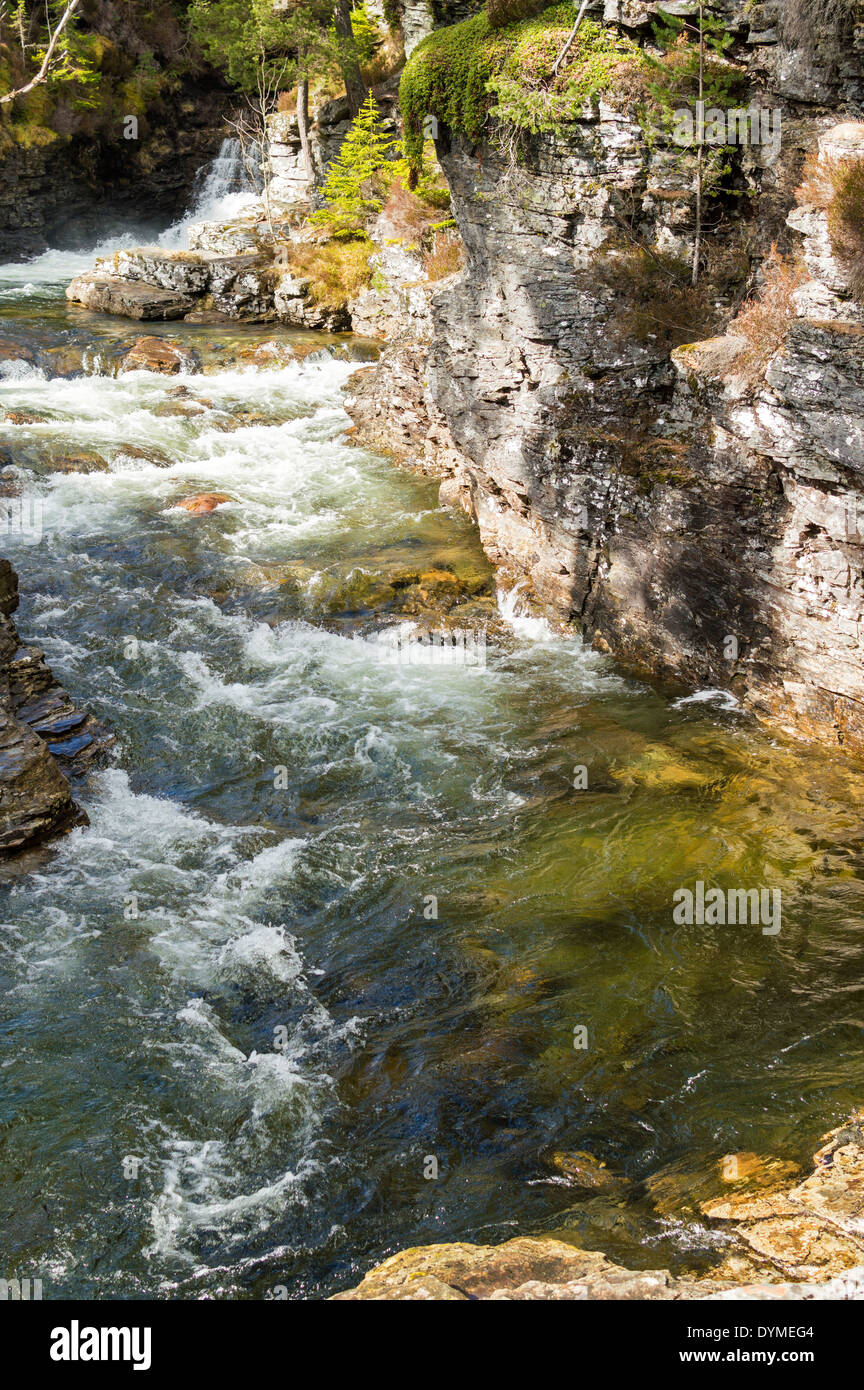 Neve verde acqua di fusione in una gola rocciosa di lui fiume vicino a Braemar in Scozia Foto Stock