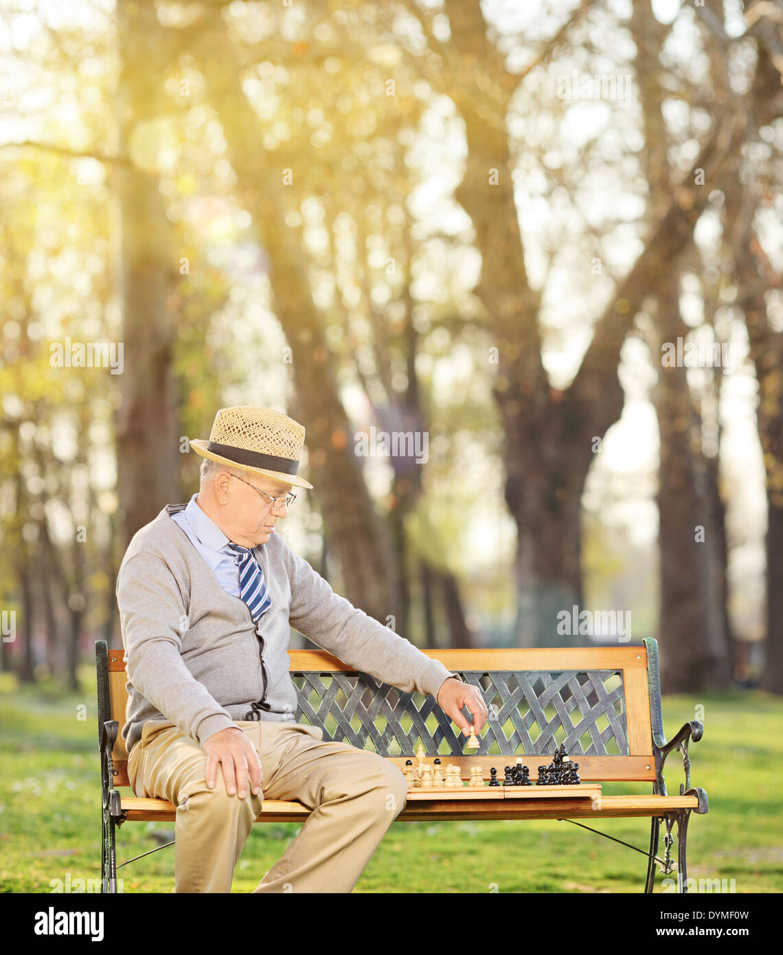 Senior giocando a scacchi da solo in posizione di parcheggio Foto Stock