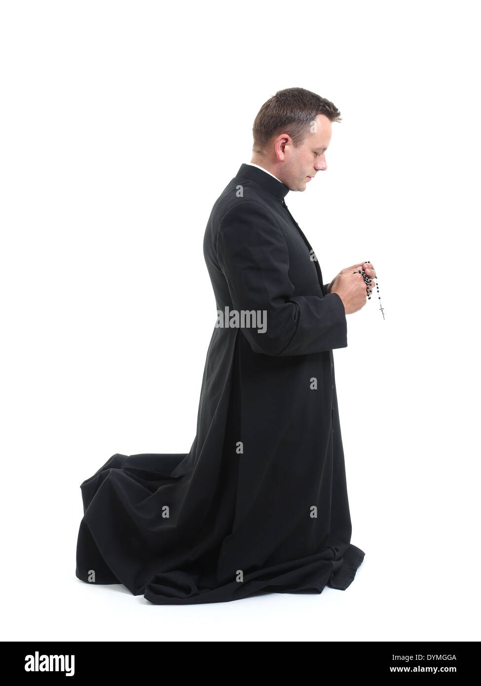 Sacerdote cattolico in ginocchio e dicendo il suo rosario Foto Stock