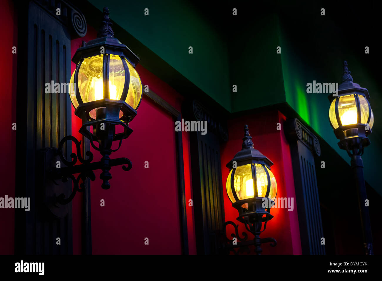 Vintage lampioni di sera sulla parete rossa sullo sfondo Foto Stock