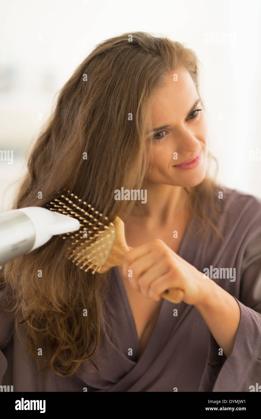 Giovane donna soffiare i capelli di essiccazione Foto Stock