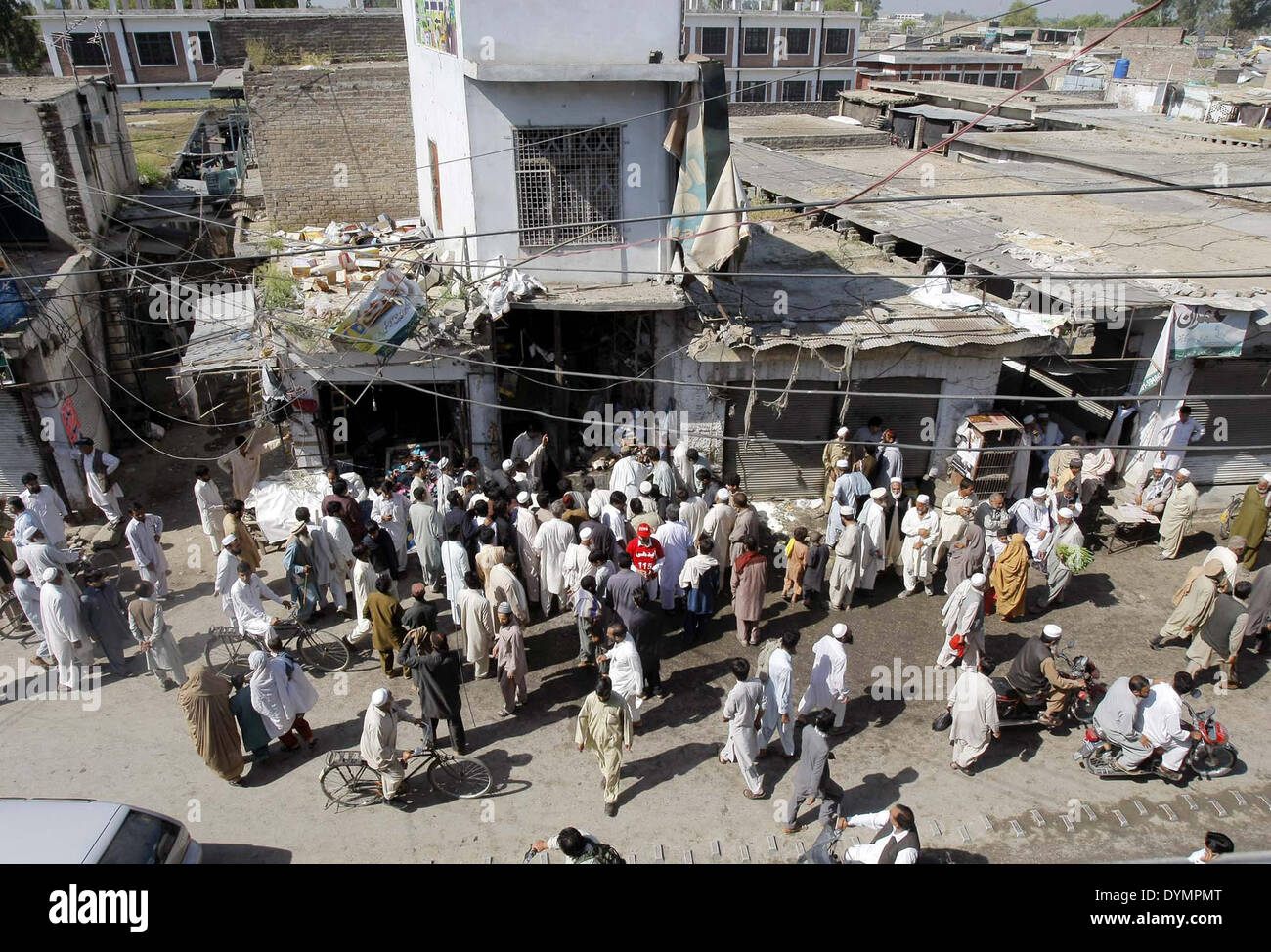 Funzionari di salvataggio e i residenti si riuniranno presso il sito dopo l esplosione di bomba attacco mirato sul veicolo di polizia a Charsadda Tehsil sul mercato Nowshera road a Peshawar Martedì, 22 aprile 2014. Almeno tre poliziotti sono stati uccisi e molti altri feriti in un'esplosione nel mercato Tehsil di Charsadda. Fonti della polizia ha detto che l'attentato si rivolge ad una polizia van nel mercato Tehsil che ha ucciso tre uomini della sicurezza mentre molti altri tra cui poliziotti sono stati feriti. Foto Stock