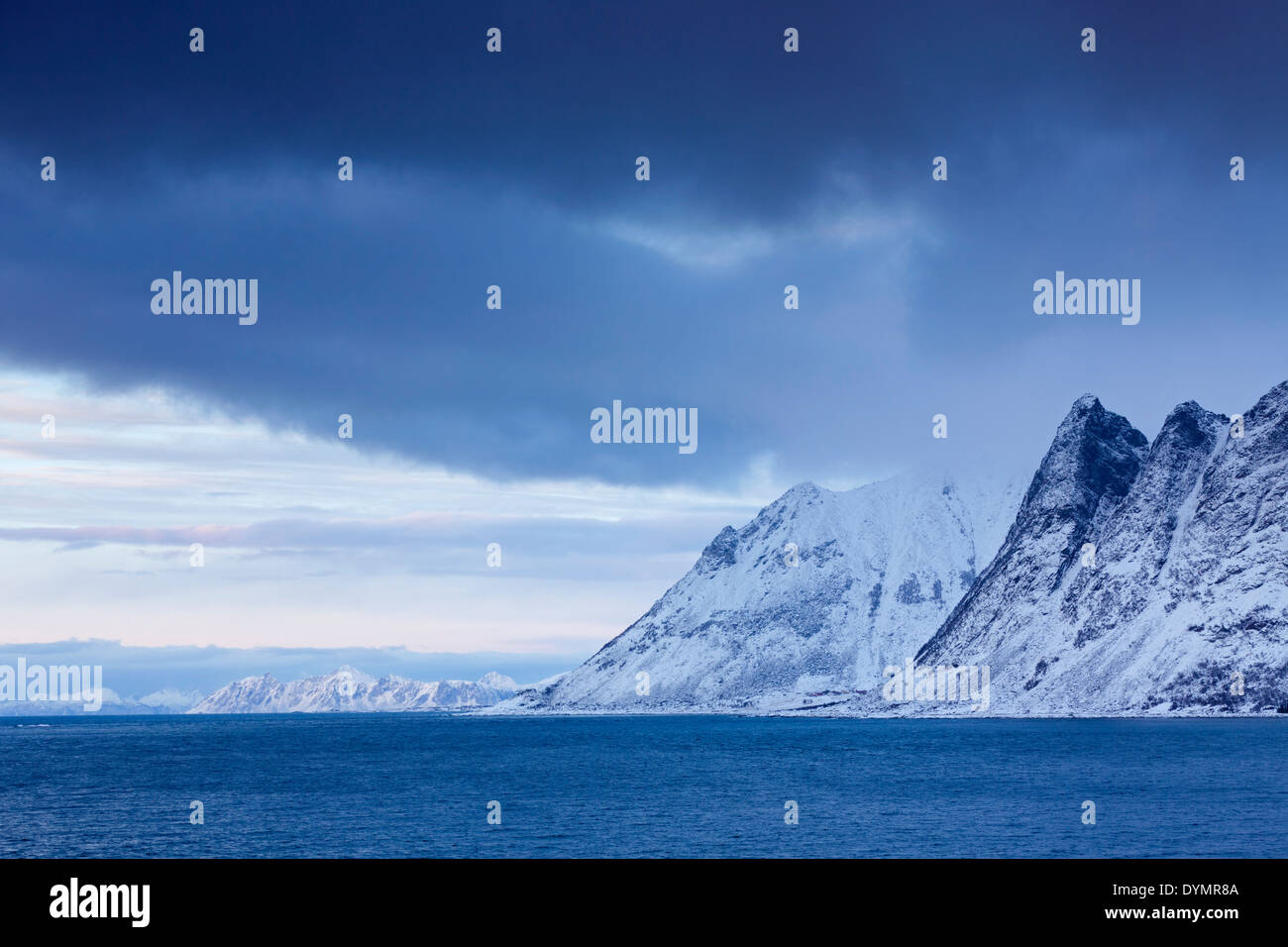 Vista sul fiordo Gimsøystraumen e le montagne della neve in inverno, Lofoten, Nordland, Norvegia Foto Stock