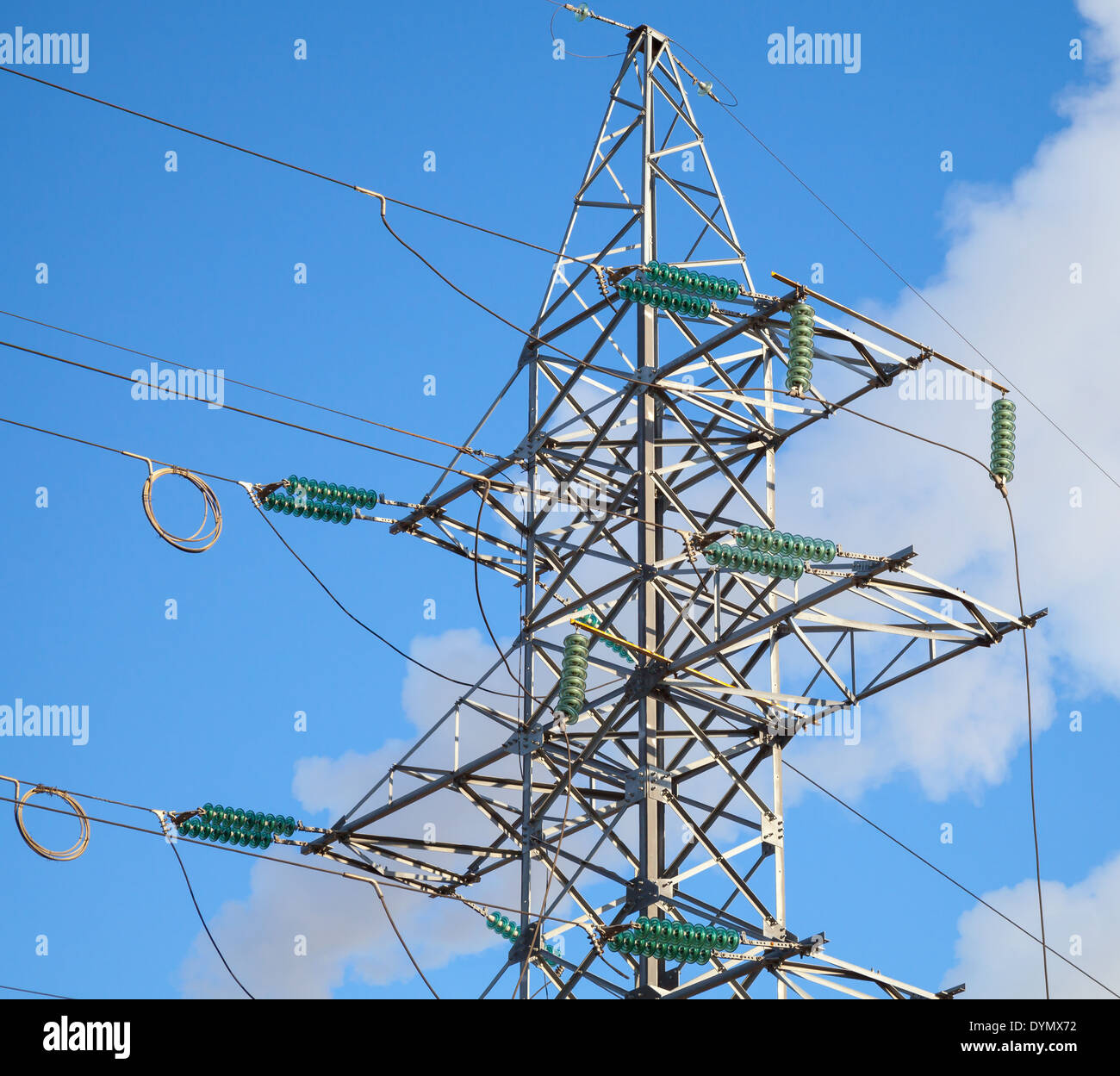 Linee elettriche ad alta tensione e grande pilone sopra cielo blu Foto Stock