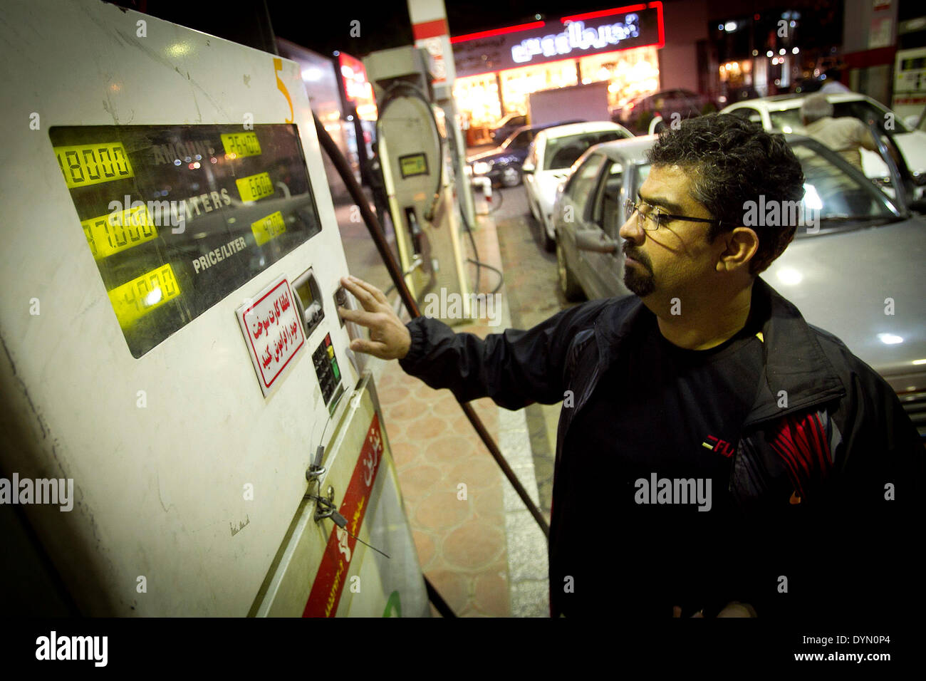 Tehran, Iran. 22 apr 2014. Un uomo refuels la sua auto in una stazione di benzina a Tehran, capitale dell'Iran, il 22 aprile 2014. Dopo funzionari iraniani ha annunciato un aumento dei prezzi del carburante nei giorni a venire la gente si precipitò per le stazioni di gas e il consumo della benzina è aumentato di oltre il 100%. Credito: Ahmad Halabisaz/Xinhua/Alamy Live News Foto Stock