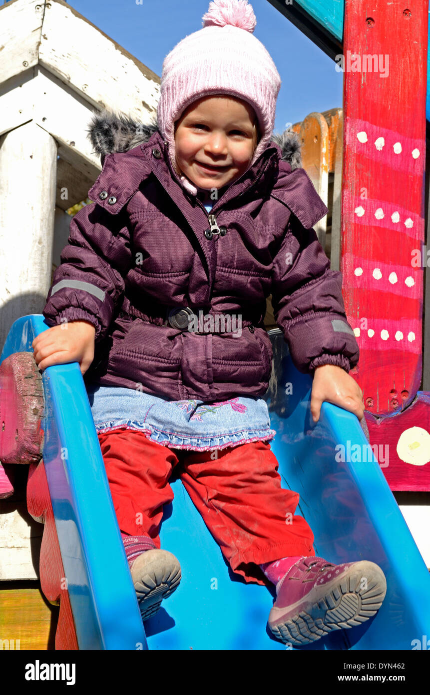 Bambina nella parte superiore dello scivolo in un parco giochi a Budapest Ungheria Foto Stock