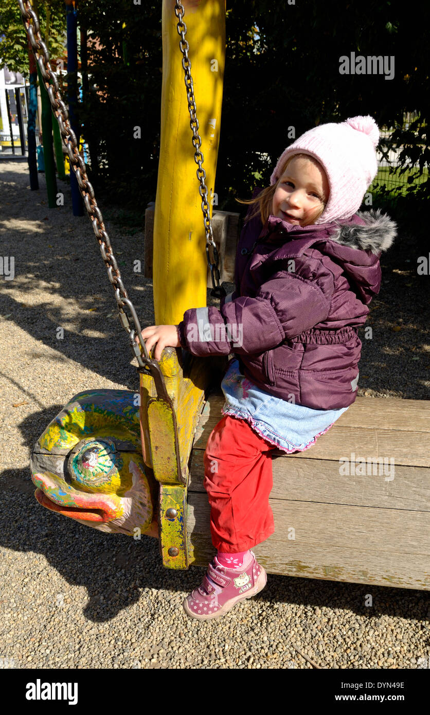 Bambina oscillare sul parco giochi toy Foto Stock