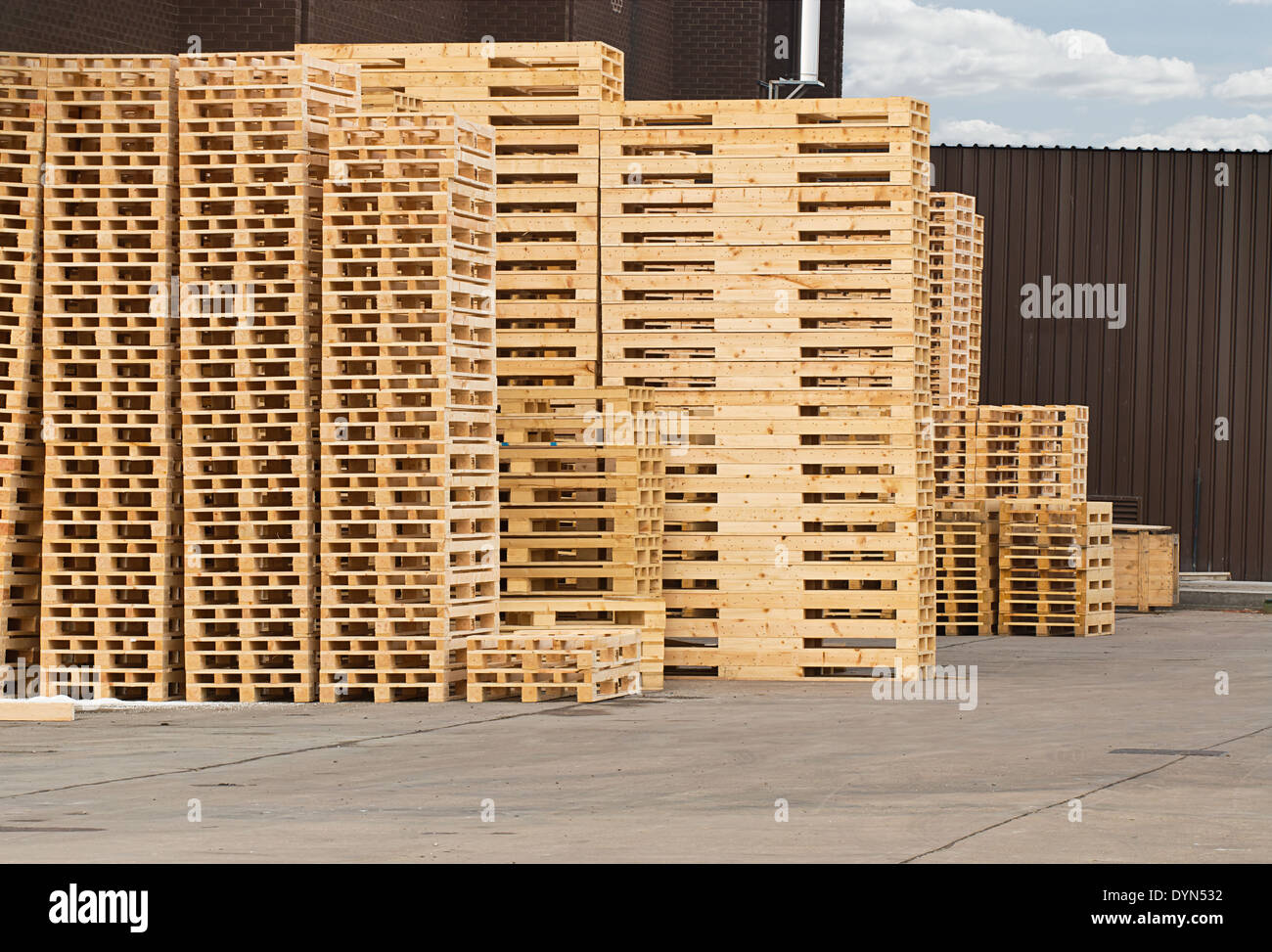 Stock pile di pallet in legno in un cantiere pronto per la frantumazione e riciclaggio di legna da ardere o ravvivare Foto Stock