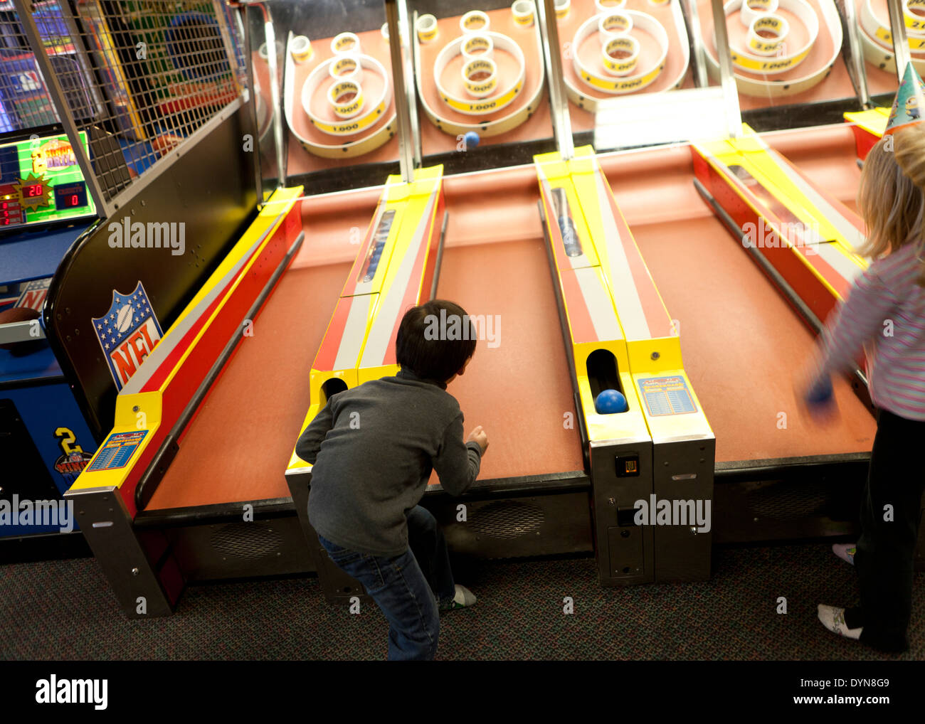 Un bambino piccolo a giocare skee ball in arcade - USA Foto Stock