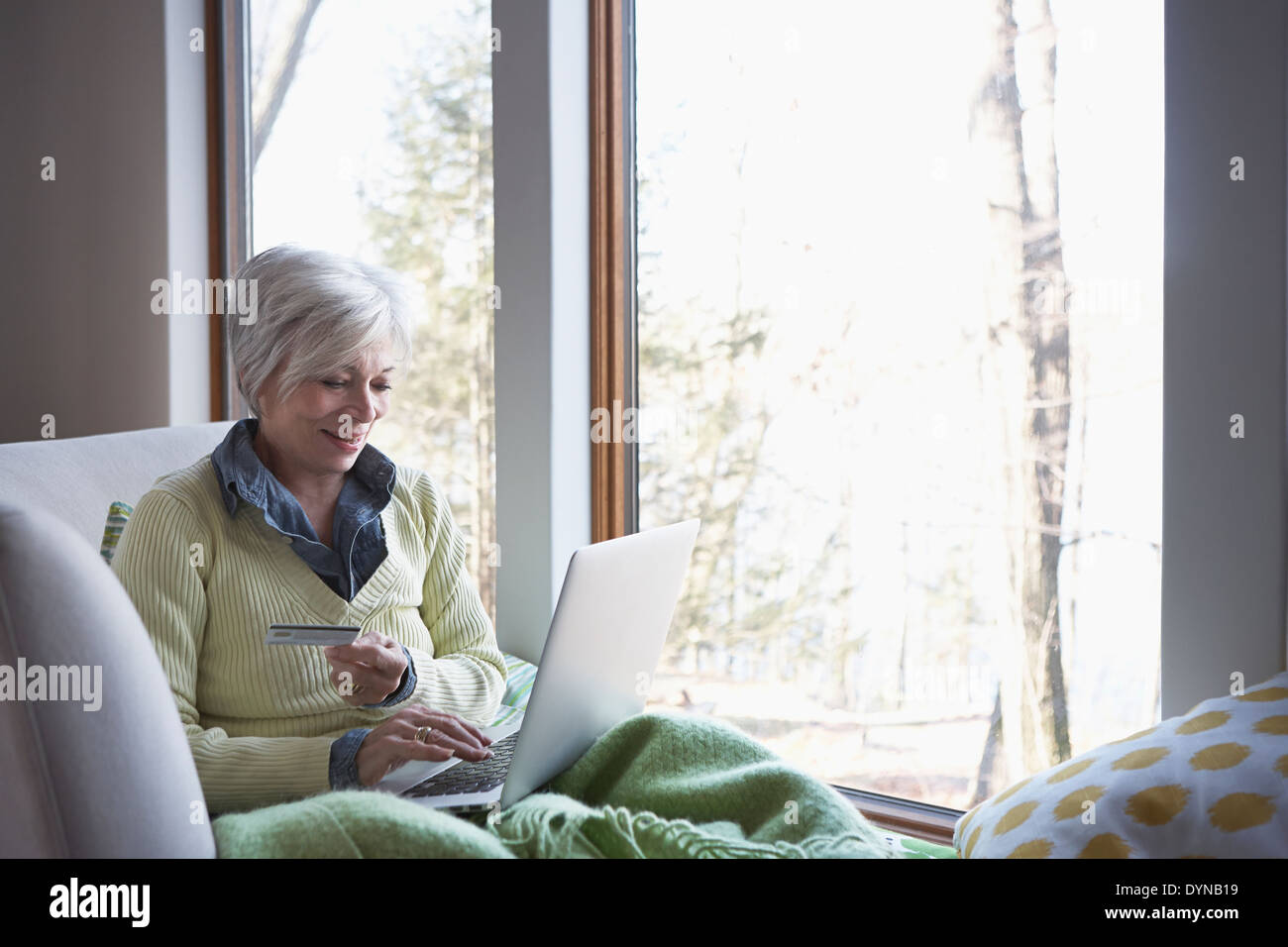 Senior donna shopping online sul divano Foto Stock