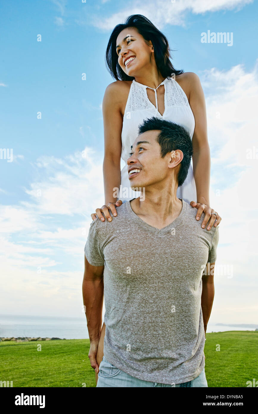 Uomo che porta la fidanzata nel paesaggio rurale Foto Stock