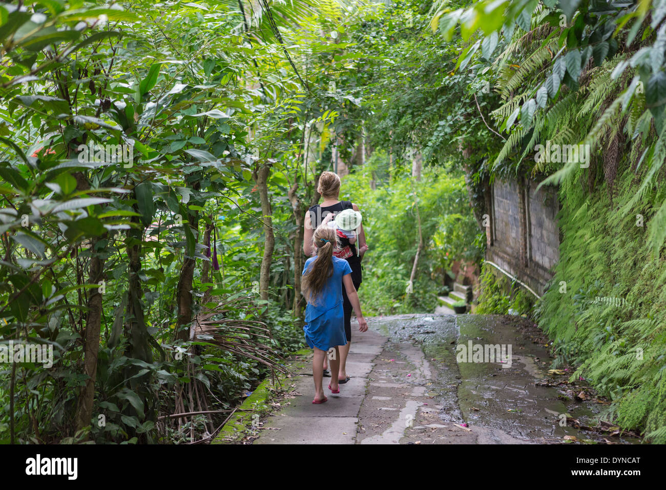 Famiglia caucasica passeggiate nel giardino tropicale Foto Stock