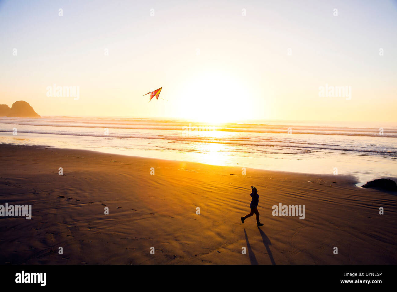 La donna caucasica aquilone volante sulla spiaggia Foto Stock