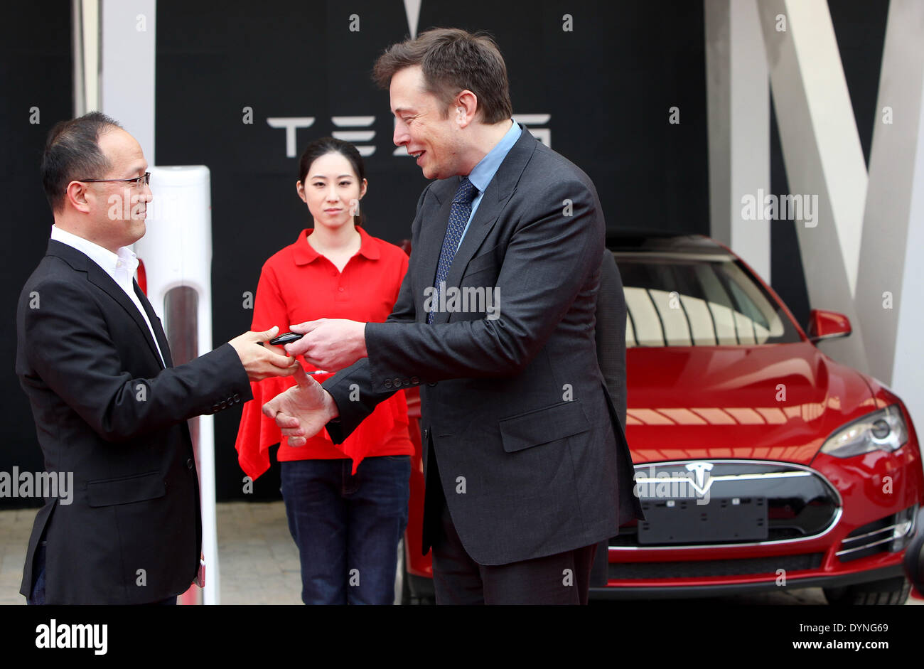 (140423) -- Shanghai, 23 aprile 2014 (Xinhua) -- Elon Musk (R), CEO di American electric car maker Tesla Motors, con le mani su una chiave di un proprietario di veicoli Tesla a Shanghai in Cina orientale, Aprile 23, 2014. Il primo compressore - stazione di ricarica di Tesla in Cina ha aperto il mercoledì e il primo gruppo di proprietari di Tesla ha ottenuto i loro veicoli. (Xinhua/Pei Xin) () Foto Stock
