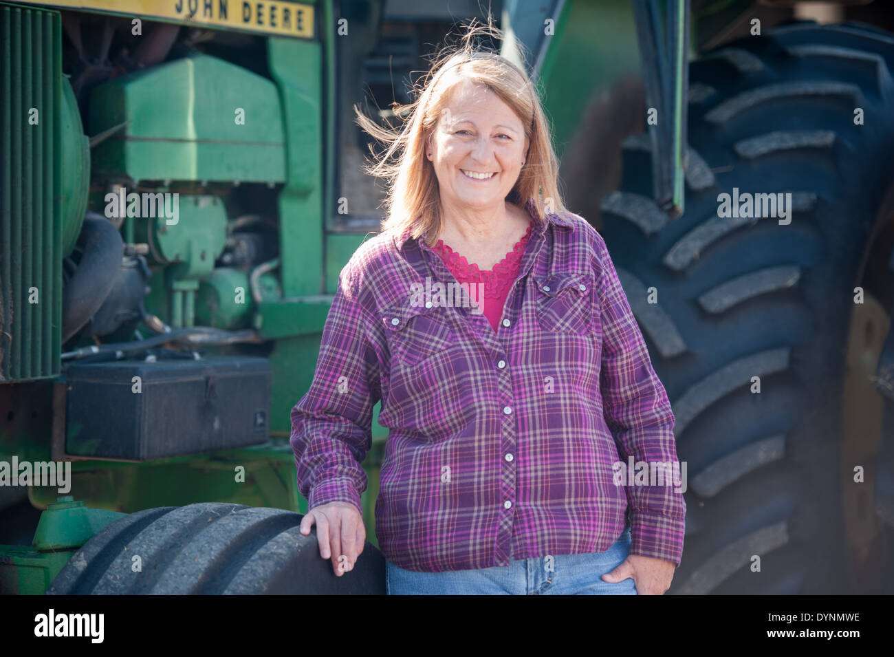 L'agricoltore femmina in plaid shirt viola in piedi nella parte anteriore del trattore Gettysburg PA Foto Stock