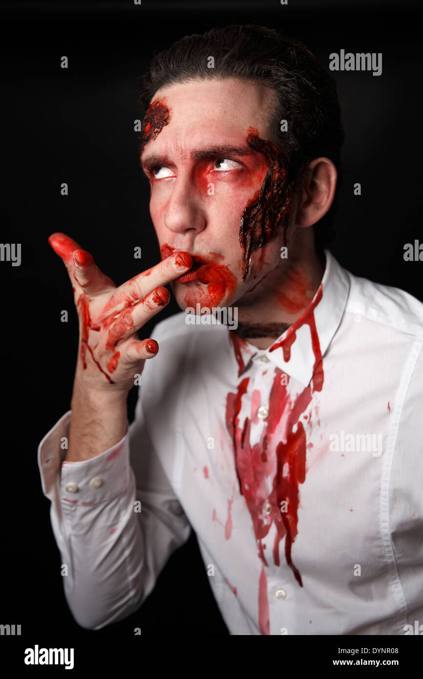 Psicopatico con il coltello insanguinato in una camicia bianca Foto Stock