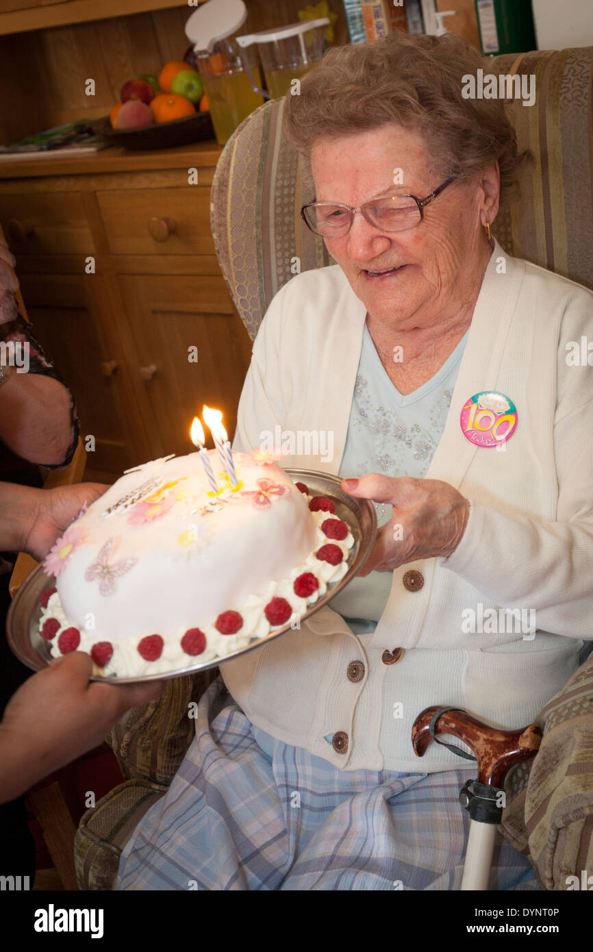 Donna anziana festeggia il suo centesimo compleanno con una torta. Foto Stock