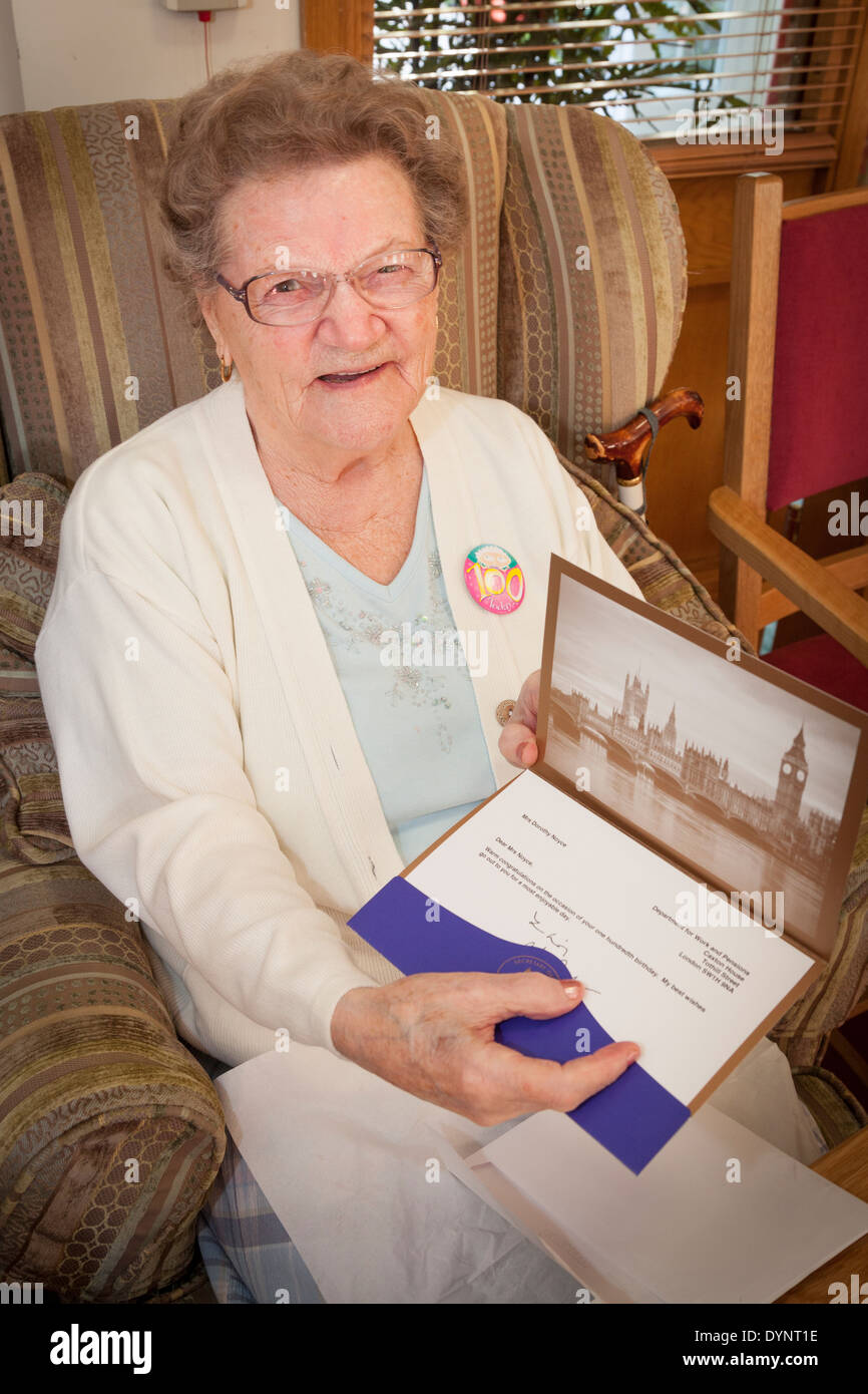 Donna anziana con il suo centesimo compleanno di carta dal Segretario di Stato per il lavoro e le pensioni. Foto Stock