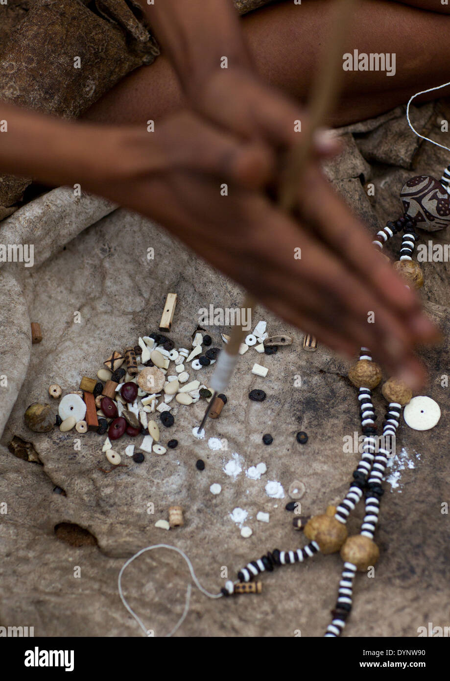 Donna boscimane facendo collane con uovo di struzzo Shell, Tsumkwe, Namibia Foto Stock
