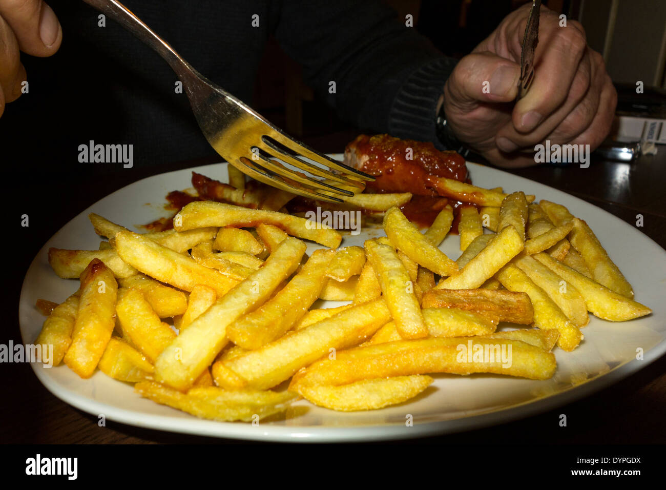 Il tedesco di fast food, ( currywurst ) essendo mangiato dalla piastra. Foto Stock