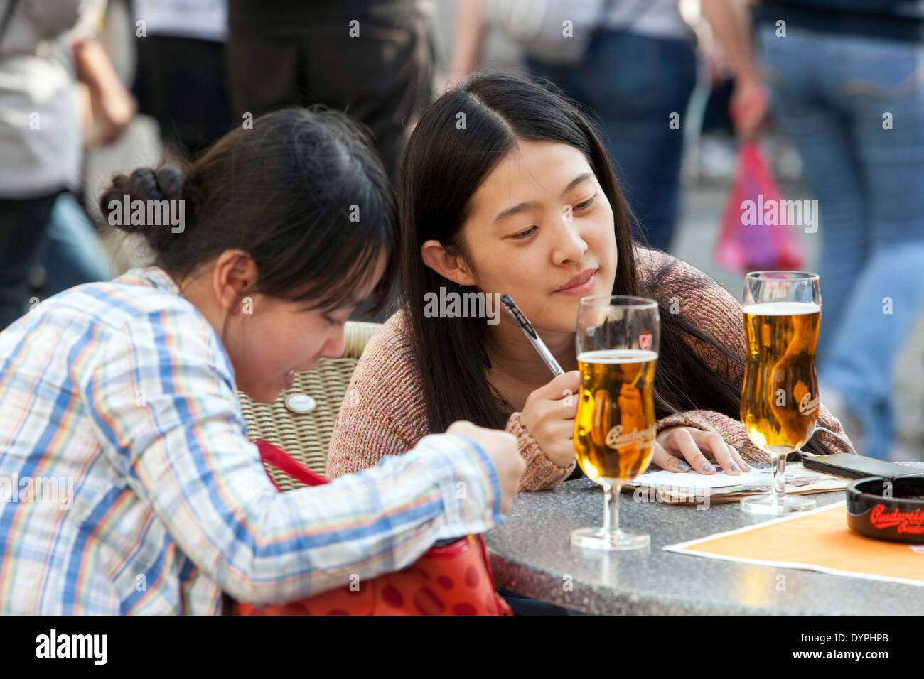I giovani turisti asiatici nel centro della città riposano in un bar di strada, Piazza della città Vecchia Praga Repubblica Ceca Turismo giovani donne asiatiche Foto Stock