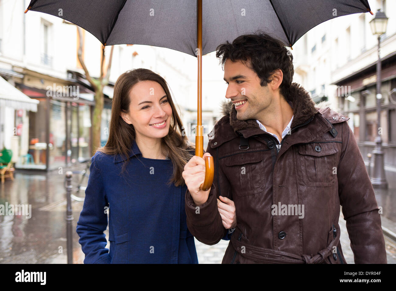 Sorridenti donna uomo ombrello doccia Foto Stock